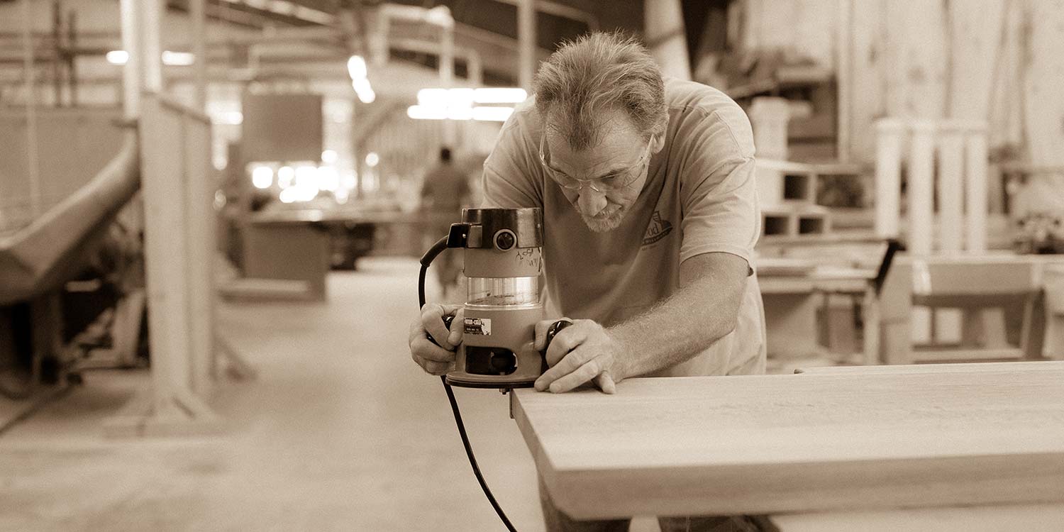 An image of a Kstair worker trimming up the edges of a piece of lumber
